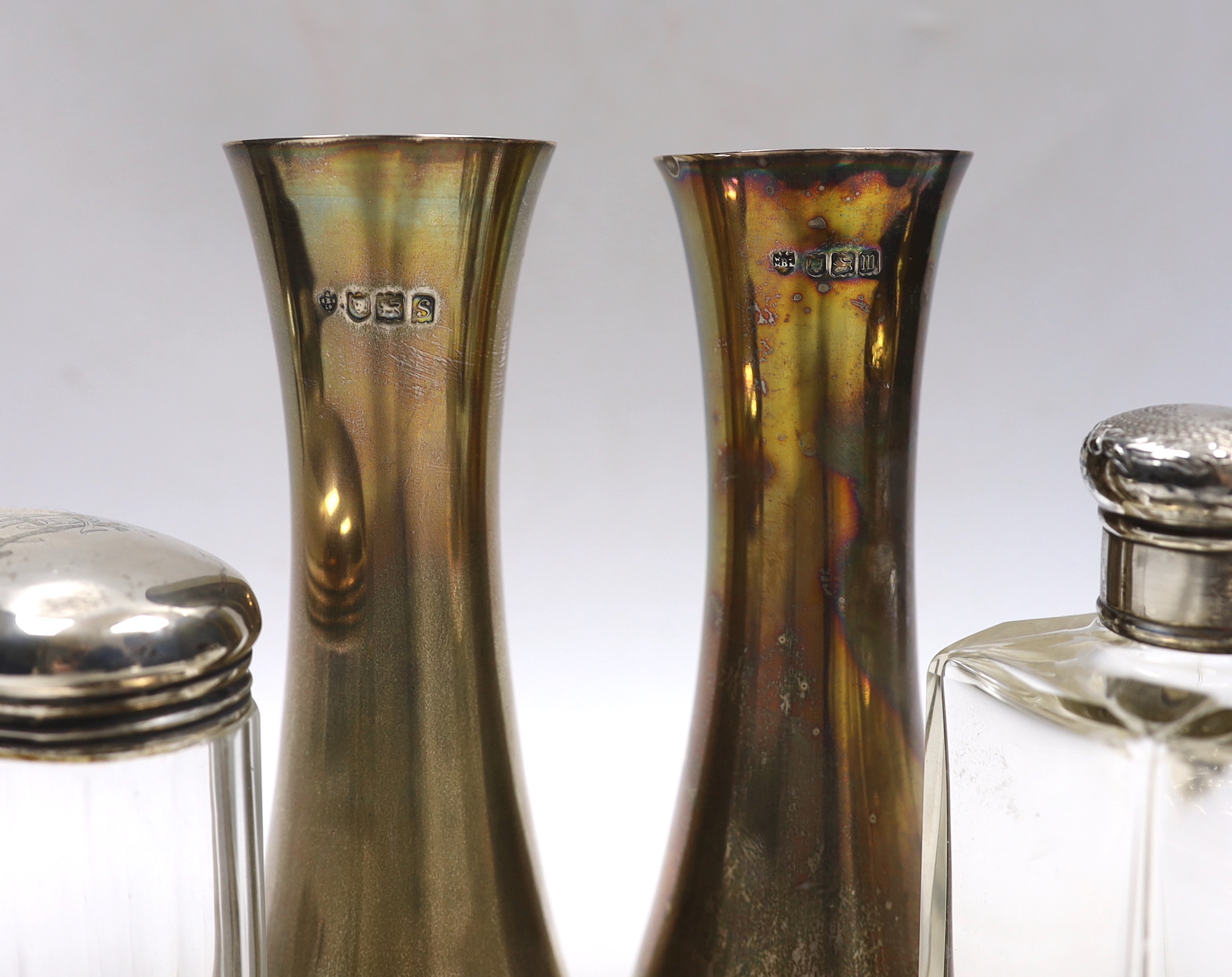 A pair of Edwardian silver waisted spill vase, London, 1907, 15cm, six silver mounted glass toilet jars, a silver mounted hand mirror and comb.